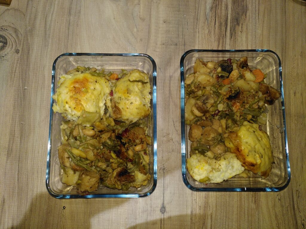 Leftover stew and dumplings in a glass tupperware container.