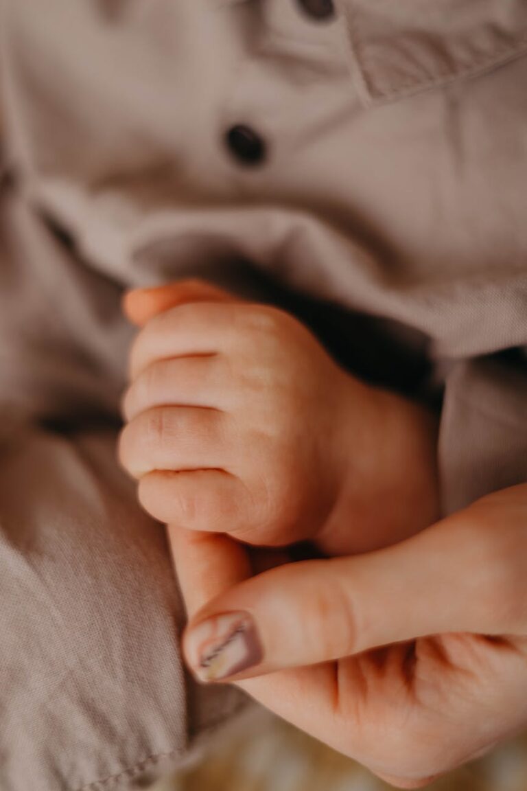 Infant holding their mother's finger in their tiny fist. Chosen by the author to depict the bond between mother and child, and the difficult decision over whether to return to work after maternity leave.