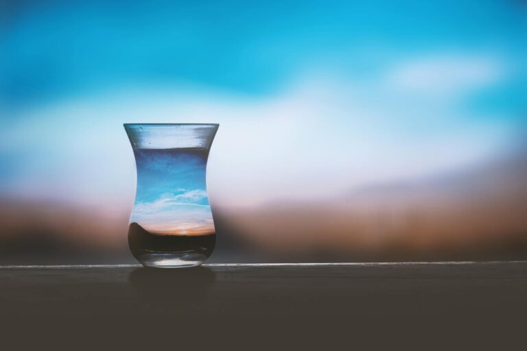 A vase containing water in the foreground, acting to focus the sky and landscape which is otherwise blurred in the background. Chosen by the author as a metaphor for focusing on the simple things in life and seeing beauty and joy in those things.